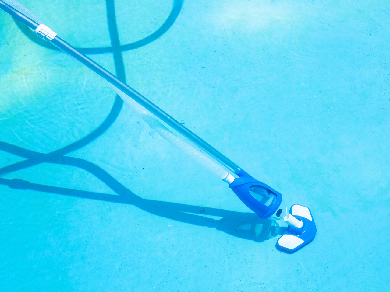 cleaning-bottom-of-swimming-pool-by-underwater-vacuum-cleaner