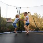 Siblings-having-fun-as-they-jump-on-trampoline
